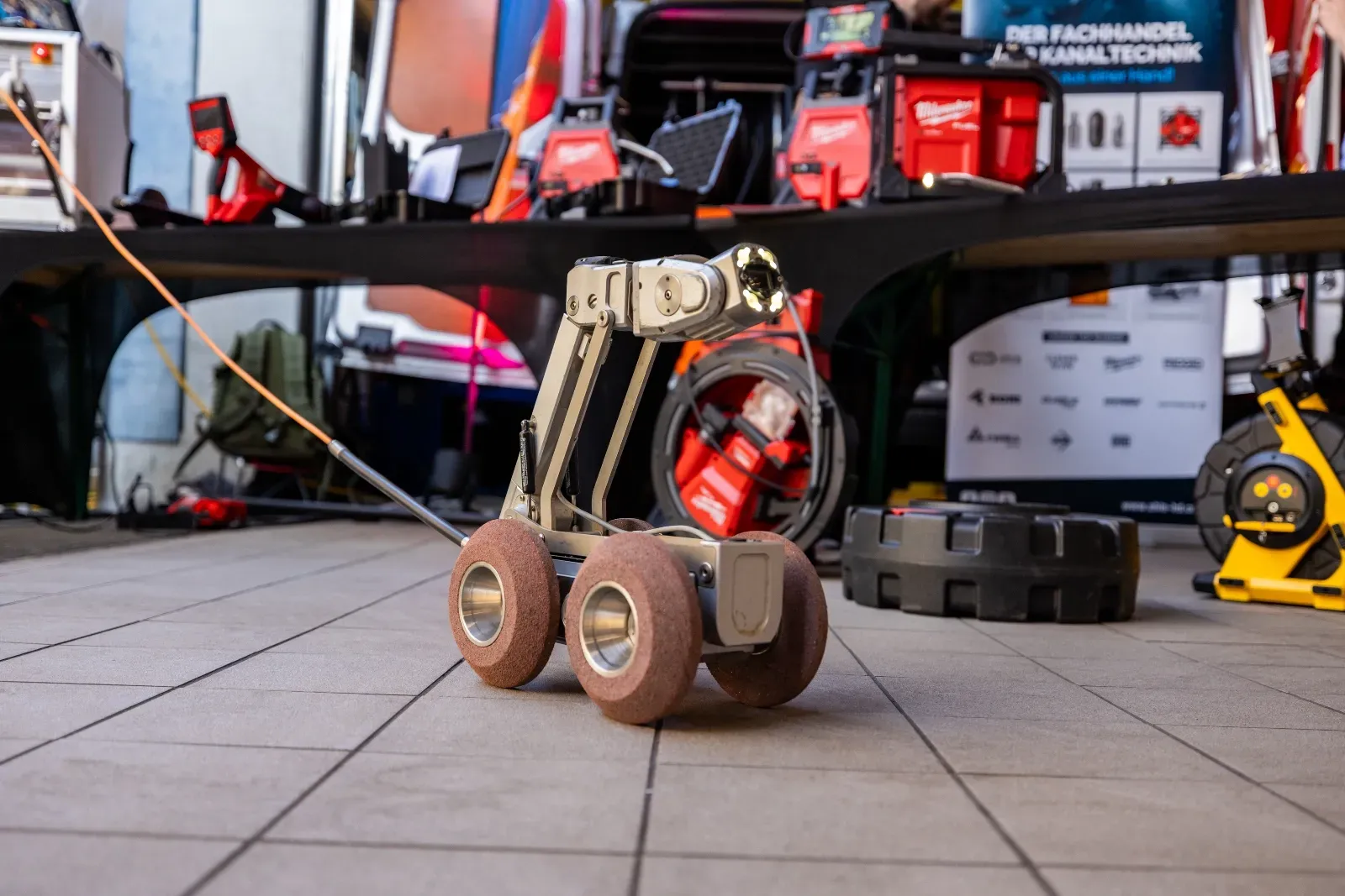 Ein Kanalroboter auf Rädern am Hallenboden vor dem Werkzeugstand
