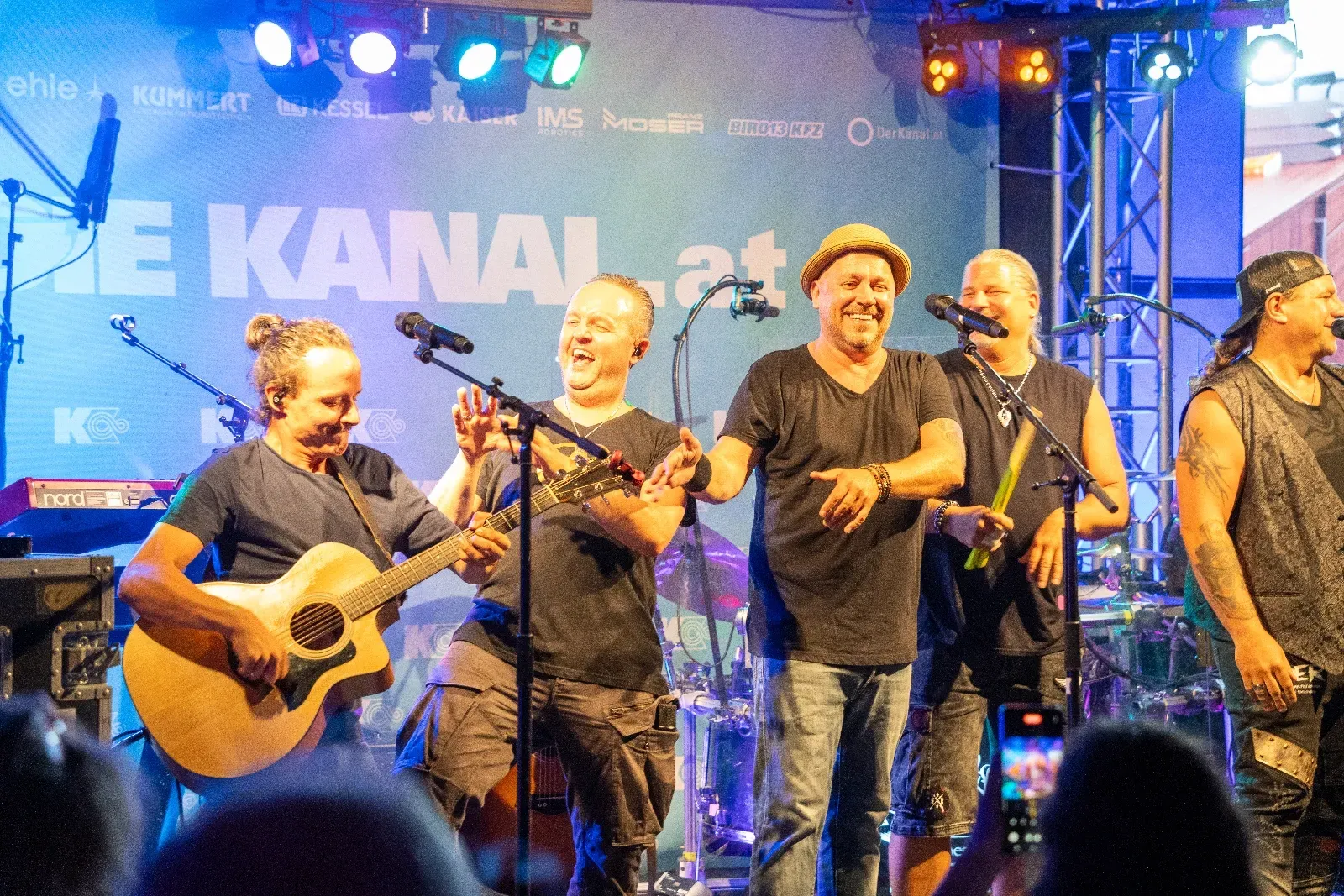 Band auf der Bühne vor der DIE-KANAL-Wand im blauen Scheinwerferlicht